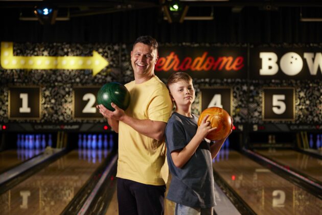 image of boy and parent bowling