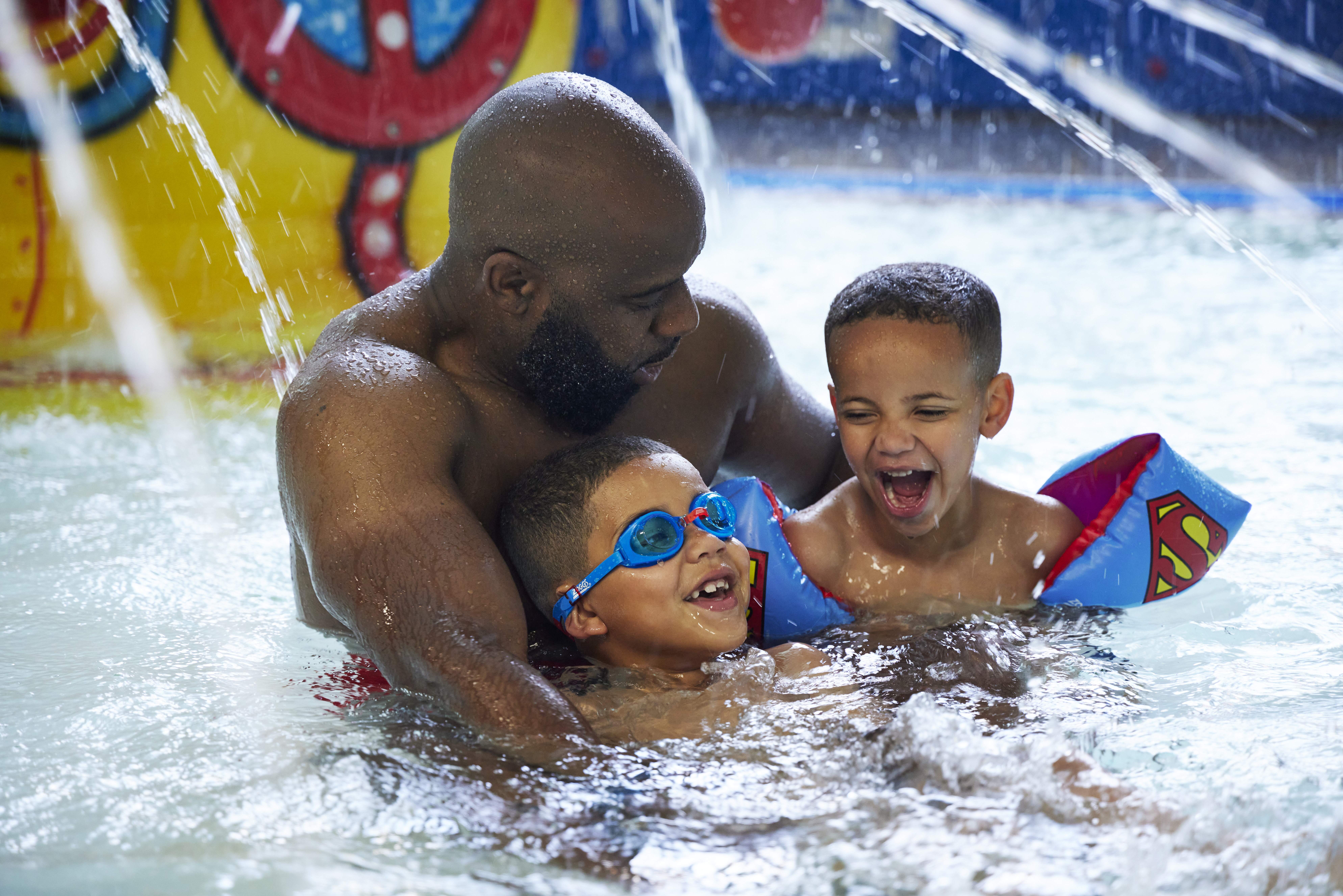 Man and kids in swimming pool